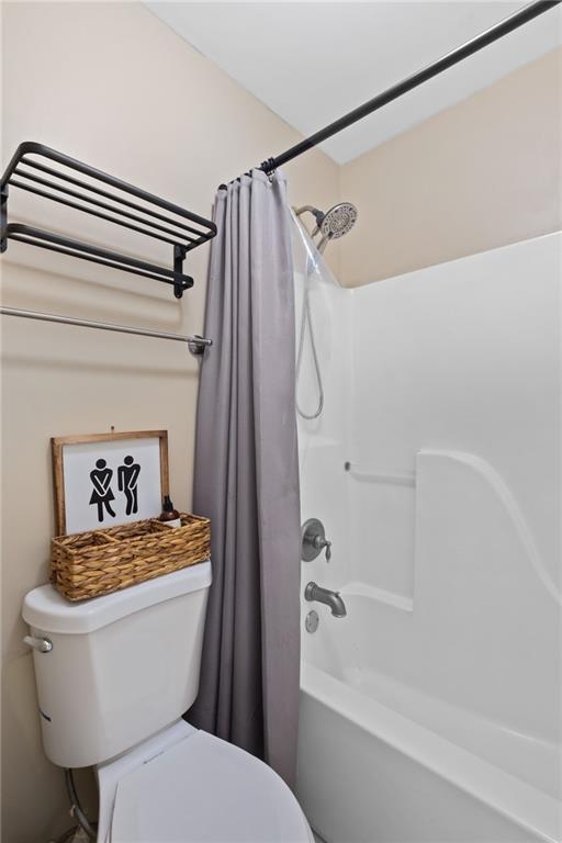 full bathroom with toilet and shower / bathtub combination with curtain