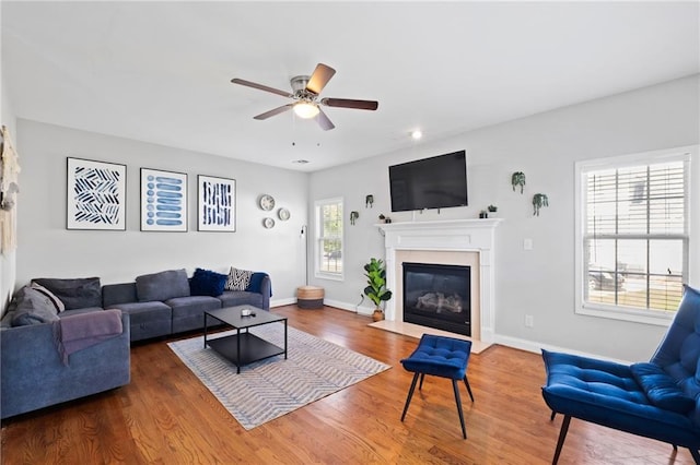 living room featuring ceiling fan, wood finished floors, a fireplace with flush hearth, baseboards, and recessed lighting
