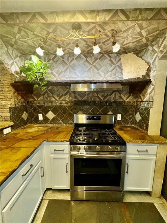 kitchen featuring white cabinetry, tasteful backsplash, stainless steel range with gas stovetop, and extractor fan