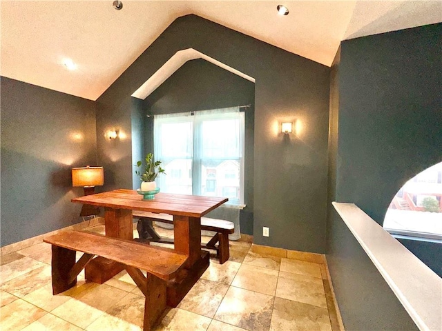 dining room featuring vaulted ceiling and baseboards