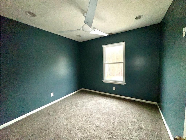 spare room featuring carpet and baseboards