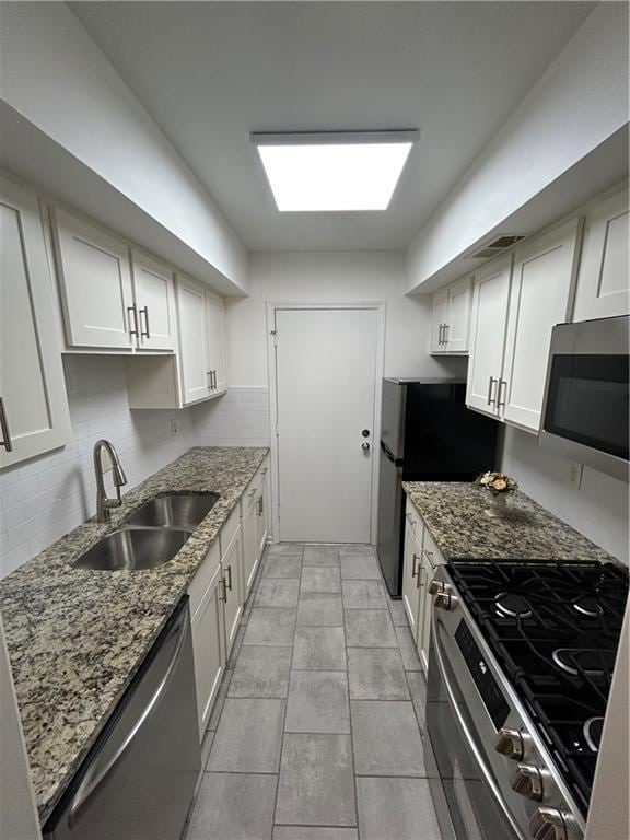 6851 Roswell Rd Unit O10, Atlanta, GA 30328 - kitchen with appliances with stainless steel finishes, decorative backsplash, light stone countertops, and white cabinets