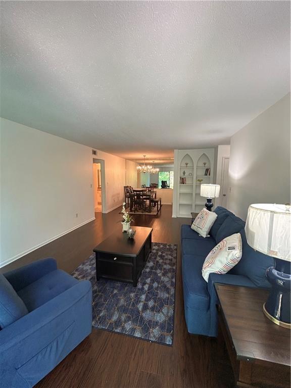 6851 Roswell Rd Unit O10, Atlanta, GA 30328 - living room featuring wood finished floors, a chandelier, and a textured ceiling