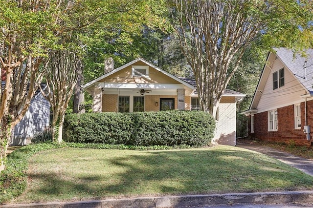 bungalow-style home with ceiling fan and a front yard