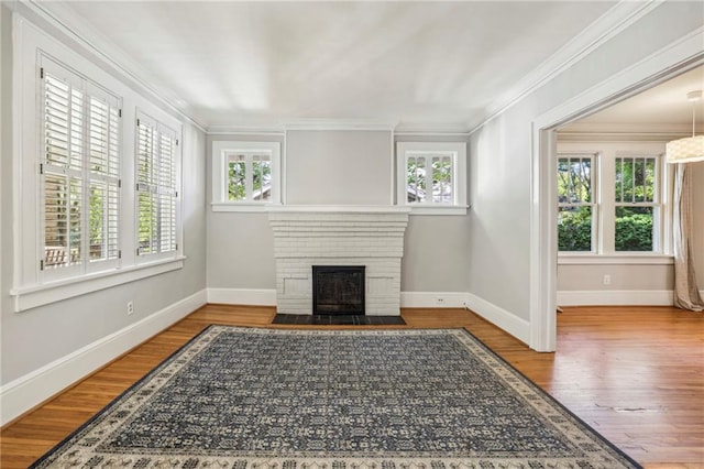 living room with hardwood / wood-style flooring, crown molding, and a fireplace