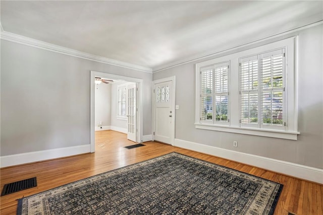 entrance foyer with ceiling fan, light hardwood / wood-style floors, and ornamental molding