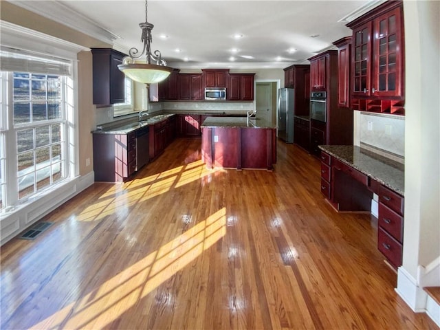 kitchen with pendant lighting, a center island, tasteful backsplash, appliances with stainless steel finishes, and sink