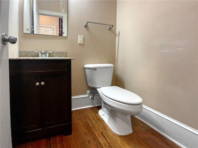 bathroom with toilet, vanity, and hardwood / wood-style floors