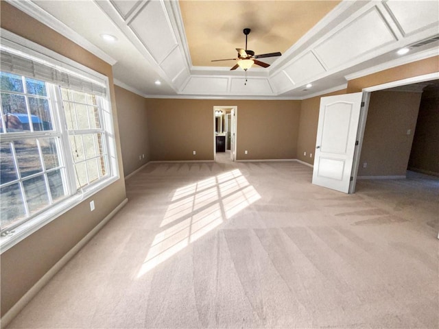 interior space featuring a raised ceiling, ornamental molding, ceiling fan, and light colored carpet