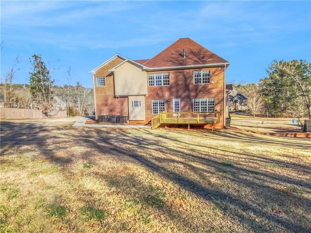 rear view of house with a deck and a lawn