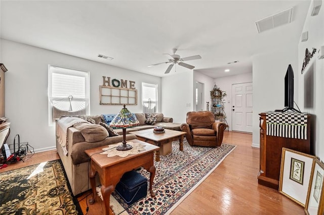 living room featuring light hardwood / wood-style flooring and ceiling fan