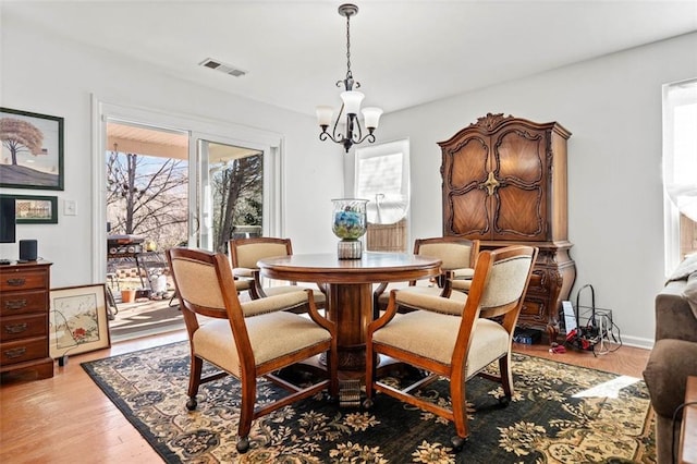 dining area with a notable chandelier and light wood-type flooring