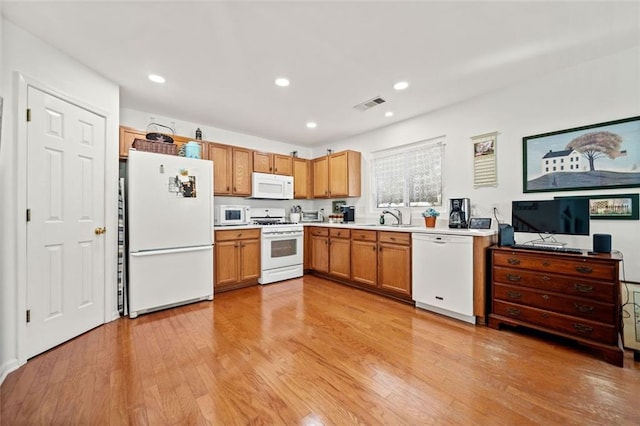 kitchen featuring sink, white appliances, and light hardwood / wood-style floors