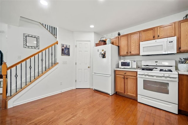 kitchen with white appliances and light wood-type flooring