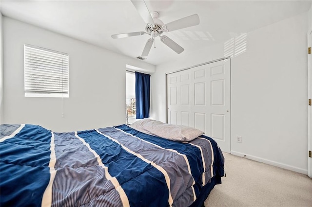 carpeted bedroom with multiple windows, a closet, and ceiling fan