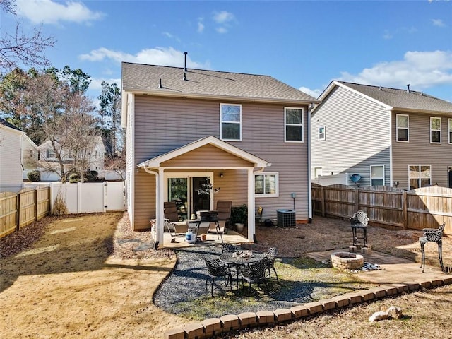 rear view of house with a patio, central AC unit, and a fire pit