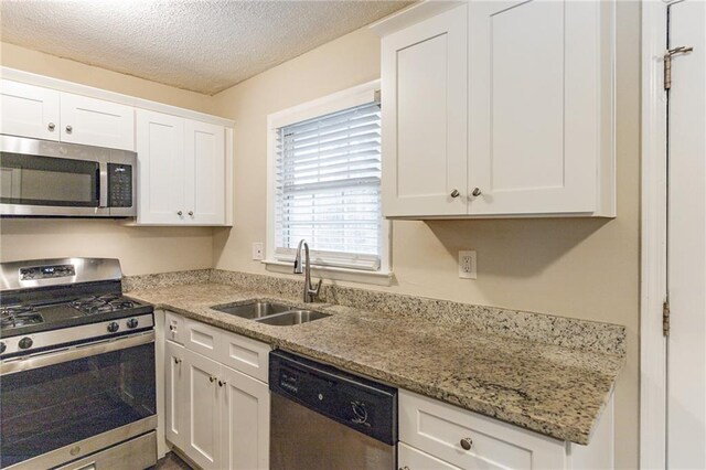 453 Utoy Cir SW, Atlanta, GA 30331 - kitchen with white cabinetry, sink, stainless steel appliances, and a textured ceiling