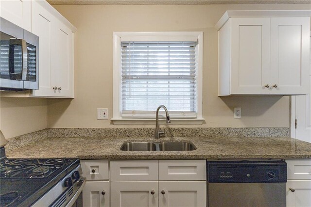 453 Utoy Cir SW, Atlanta, GA 30331 - kitchen featuring light stone countertops, sink, white cabinets, and appliances with stainless steel finishes