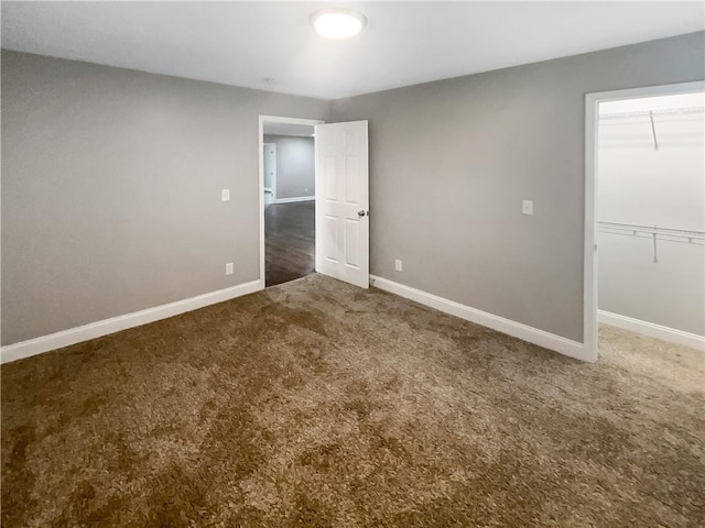 unfurnished bedroom with a closet and dark carpet