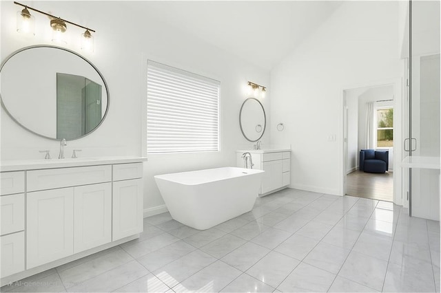 6355 Westfallen Overlook, Cumming, GA 30040 - bathroom featuring a sink, vaulted ceiling, two vanities, baseboards, and a freestanding tub