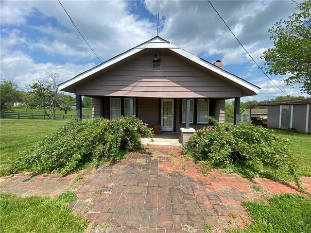 bungalow with a front lawn and covered porch