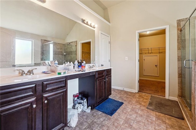 bathroom with vanity, lofted ceiling, and a shower with door