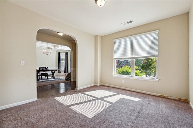 unfurnished room with a chandelier and carpet flooring