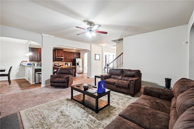 living room with light hardwood / wood-style flooring and ceiling fan