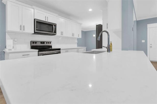 170 Early Sundown Rd, Clarkesville, GA 30523 - kitchen with appliances with stainless steel finishes, backsplash, white cabinetry, ornamental molding, and light countertops