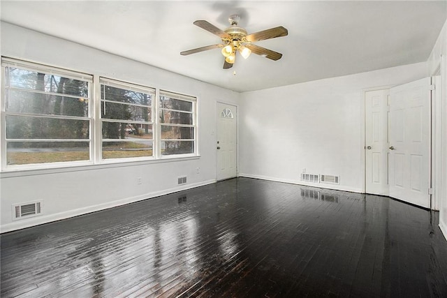 empty room featuring dark wood-type flooring and ceiling fan