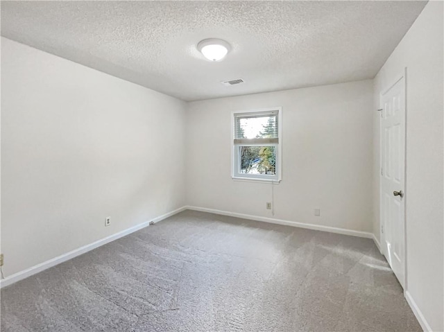 empty room featuring a textured ceiling and carpet flooring