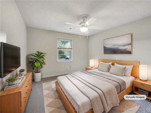 carpeted bedroom with a textured ceiling and ceiling fan