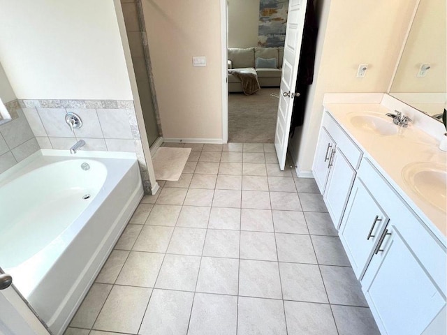 799 Blue Juniper Cir, Loganville, GA 30052 - ensuite bathroom featuring tile patterned floors, double vanity, a bath, and baseboards