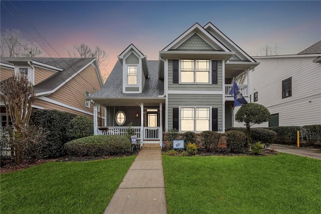 view of front of house featuring covered porch and a lawn