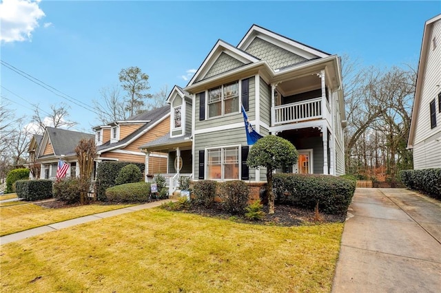 view of front of home with a balcony and a front yard