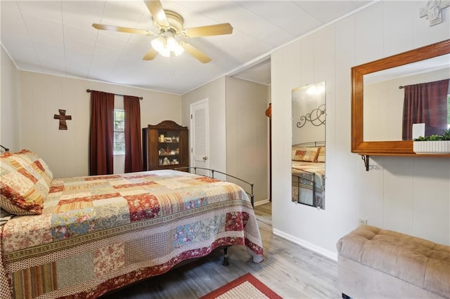 bedroom featuring ceiling fan, baseboards, ornamental molding, and wood finished floors