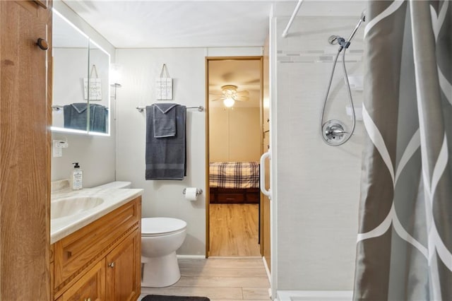 bathroom featuring wood finished floors, curtained shower, vanity, and toilet