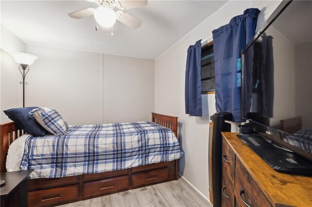 bedroom featuring baseboards, wood finished floors, and ceiling fan