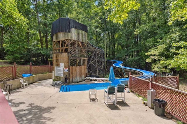 community pool with fence and a patio area