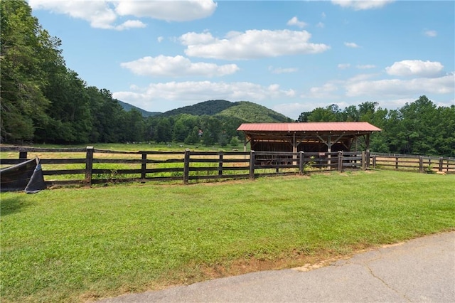 view of horse barn with a mountain view and a rural view
