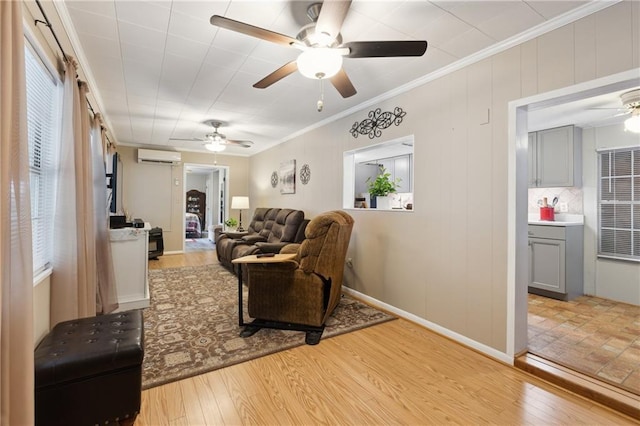 living room with a ceiling fan, ornamental molding, a wall unit AC, and light wood-style flooring