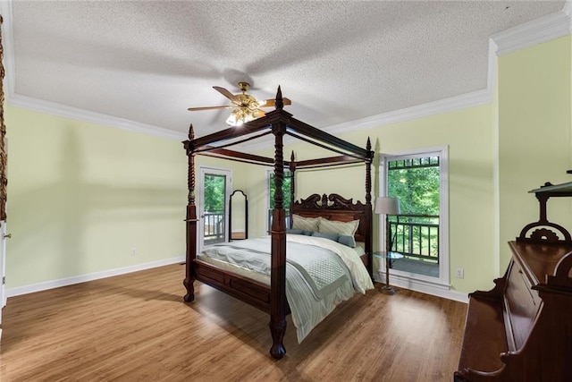 130 Wayne Wheeler Way, Woodstock, GA 30188 - bedroom featuring access to outside, multiple windows, wood finished floors, ornamental molding, and a textured ceiling