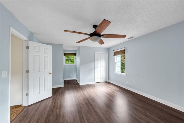 130 Wayne Wheeler Way, Woodstock, GA 30188 - unfurnished bedroom with multiple windows, a textured ceiling, a closet, dark wood-style floors, and a ceiling fan