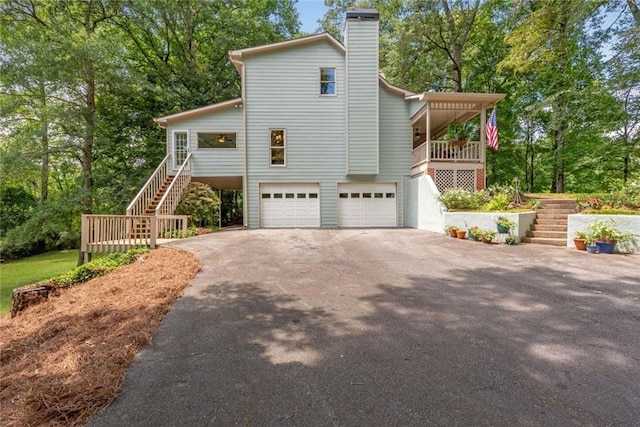 130 Wayne Wheeler Way, Woodstock, GA 30188 - view of property exterior with stairway, driveway, an attached garage, and a chimney