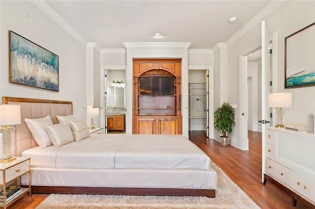 bedroom with crown molding, baseboards, and wood finished floors