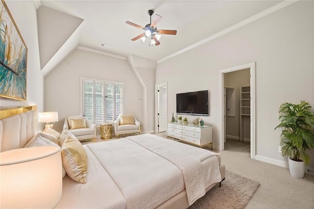 carpeted bedroom featuring lofted ceiling, visible vents, baseboards, a spacious closet, and ornamental molding