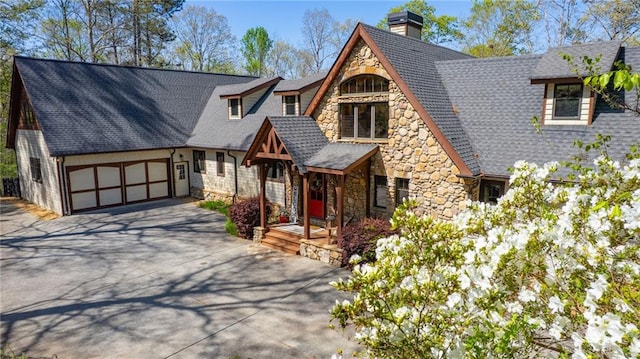 8850 Matt Hwy, Ball Ground, GA 30107 - view of front of home featuring stone siding, a chimney, concrete driveway, and a garage