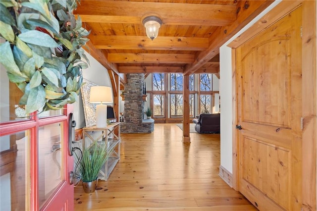 hallway featuring beamed ceiling, wooden ceiling, light wood finished floors, and ornate columns