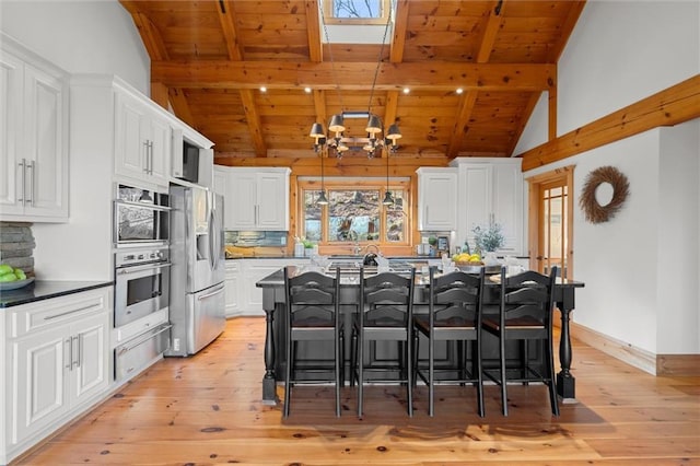 8850 Matt Hwy, Ball Ground, GA 30107 - kitchen featuring stainless steel appliances, wood ceiling with exposed beams, a warming drawer, a chandelier, and light wood-style floors
