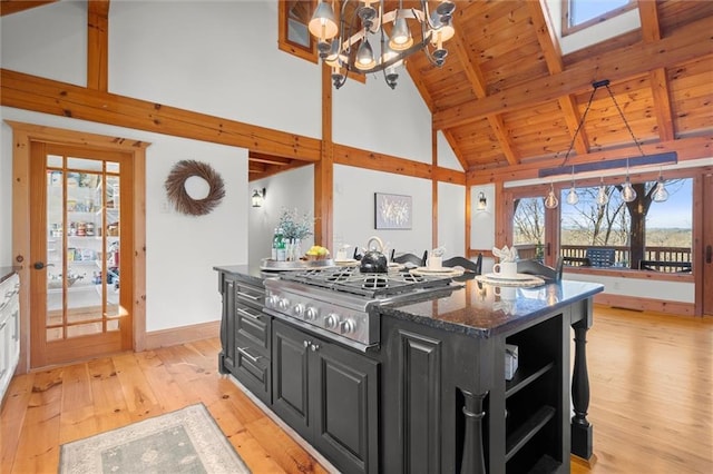 8850 Matt Hwy, Ball Ground, GA 30107 - kitchen featuring dark cabinetry, open shelves, light wood-style flooring, high vaulted ceiling, and stainless steel gas cooktop